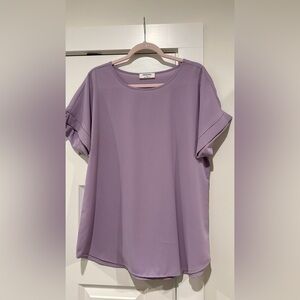 Silky lavender shirt with cuffed sleeves.